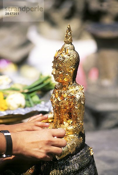 Süd-Ost-Asien  Thailand  Bangkok  Hände gelten Blattgold für Buddha-statue
