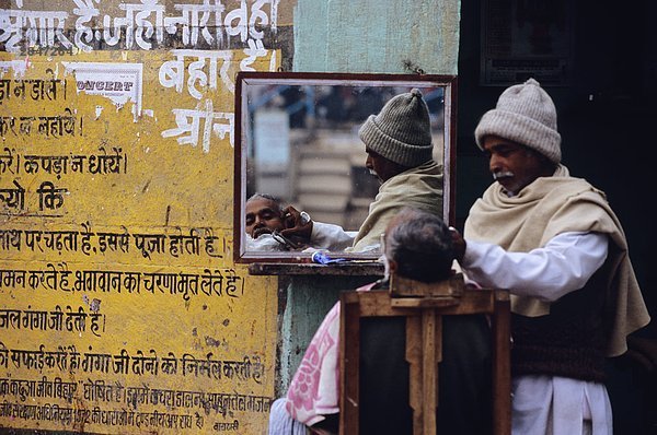 Indien  Varanasi  Barber rasiert Client in offenen Bereich.