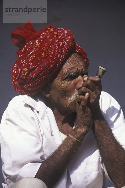 Indien  Rajastan  Samode Dorf  Mann mit Turban colorful Rauchen chilum