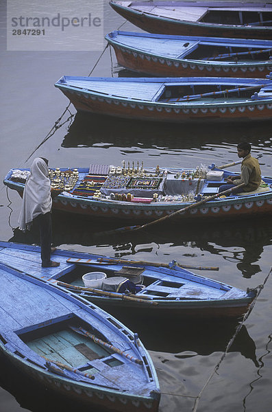 Indien  Varanasi  Dasaswamedh Ghat  junger Mann mit religiösen Symbolen im Boot verkaufen