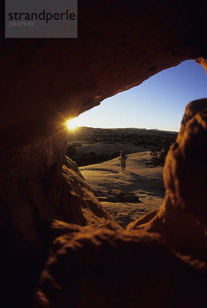 ein Radfahrer genießen eine sunset Fahrt Moab  Utah  Vereinigte Staaten.