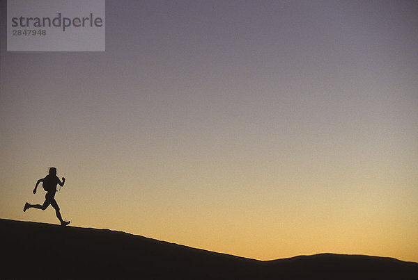 Ein Läufer Reisen Aross R??ckgrates bei Sonnenuntergang  Moab  Utah  USA.