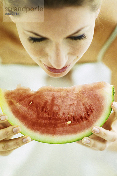 Frau isst Wassermelonenscheibe