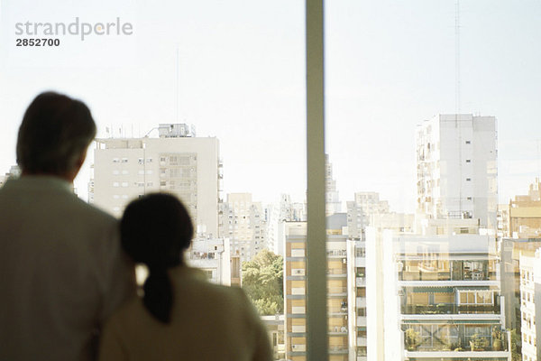 Paar  Frauenkopf auf der Schulter des Mannes  gemeinsam am Fenster mit Blick auf die Stadt