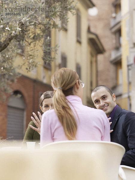 Freunde  die in einem Café auf der Piazza sitzen.