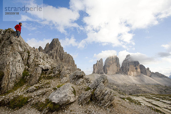 Mann auf Felsen stehend mit Blick auf Gipfel