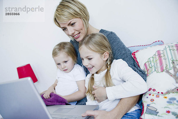 Mutter und zwei Mädchen auf dem Laptop