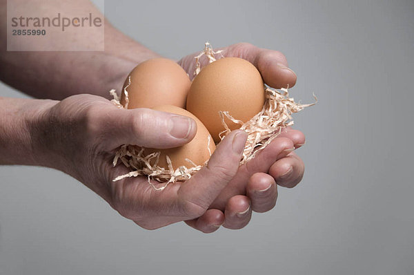 Weibliche Hand mit Eiern