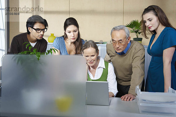 Gruppe von Personen vor dem Laptop