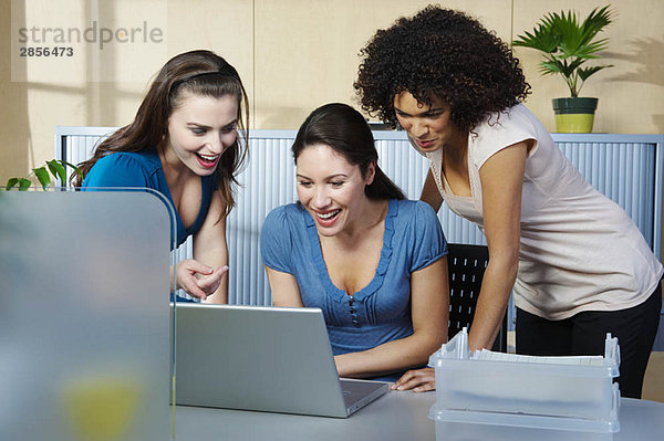 Gruppe junger Frauen mit Laptop am Schreibtisch