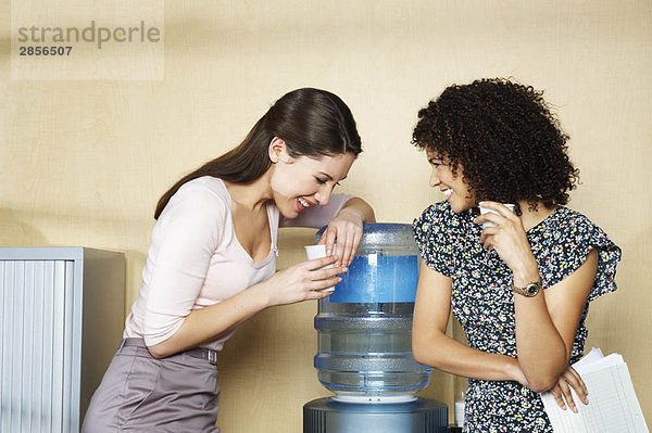 Zwei Frauen lachen am Wasserspender