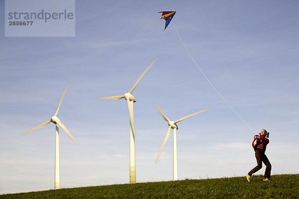 Girl Flying Kite an Windkraftanlagen