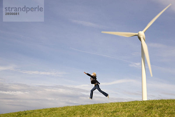 Mann springt vor Windkraftanlagen