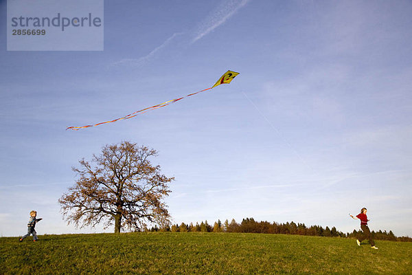 Mädchen und Junge fliegen einen Drachen