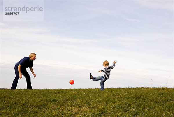 Junge und Vater spielen Ball