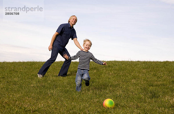 Junge und Vater spielen Ball