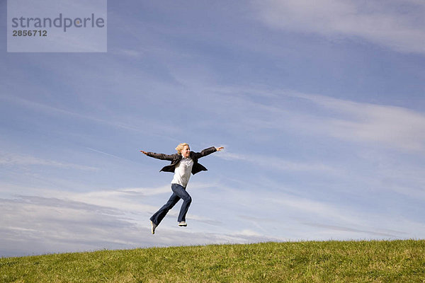 Mann springt auf Gras