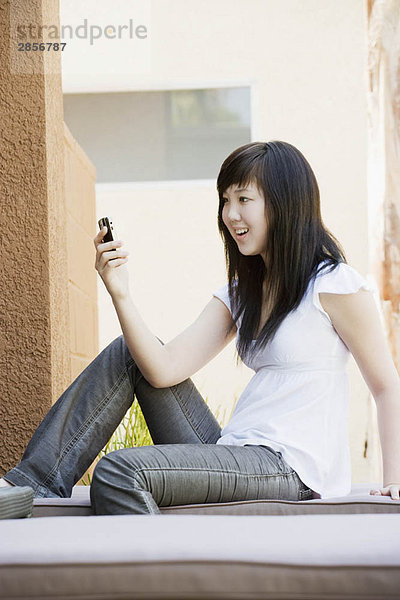 Glückliche Teenager lesen Text auf dem Handy