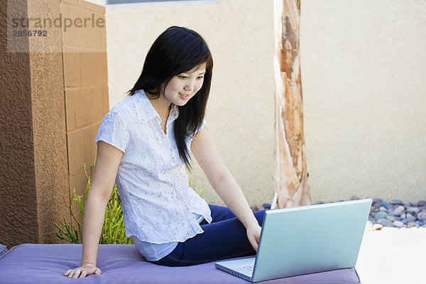 Teenager entspannen sich draußen am Laptop