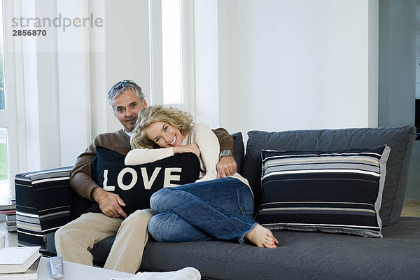 Mann und Frau auf Sofa mit Kissen