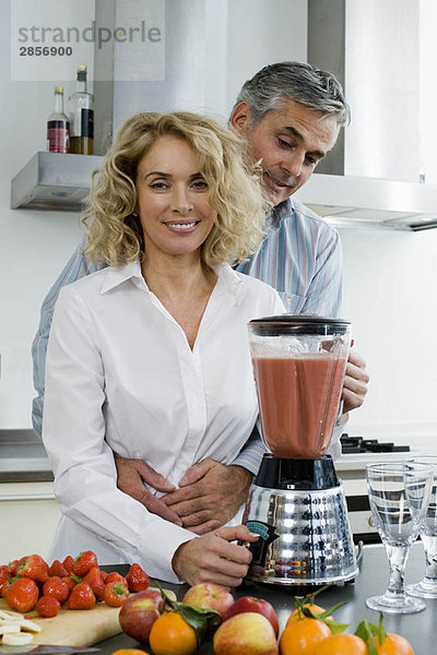 Mann und Frau bei der Zubereitung eines gesunden Getränks
