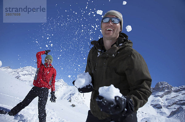 Junges Paar spielt im Schnee