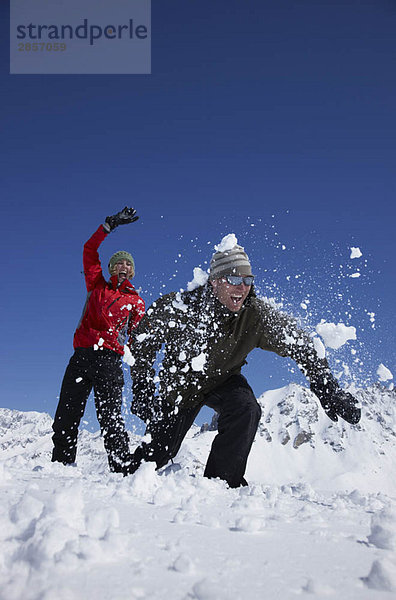 Junges Paar spielt im Schnee