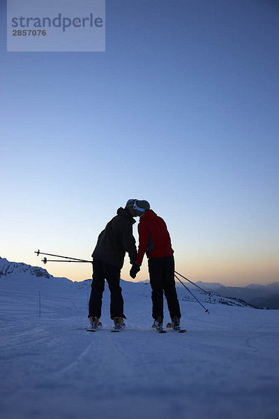 Skifahrer küssen sich auf dem Gipfel des Berges