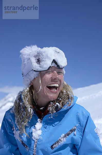 Frau lacht  Gesicht mit Schnee bedeckt