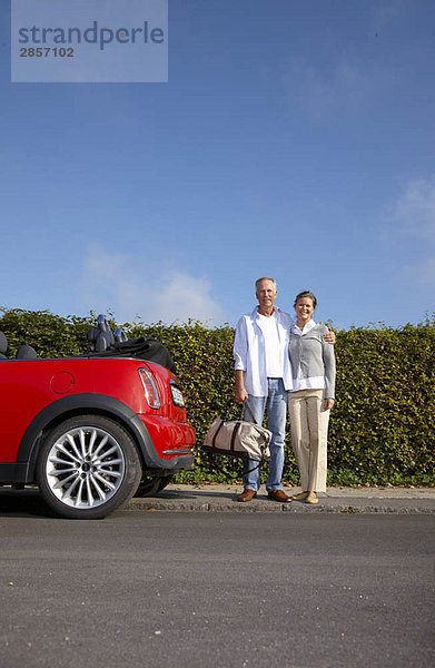 Erwachsenes Paar steht neben dem Auto