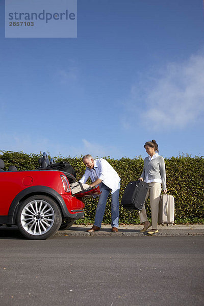 Reife Paare  die Taschen ins Auto packen