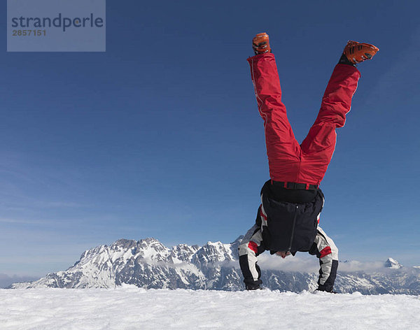 Mann mit Handstand am Berg