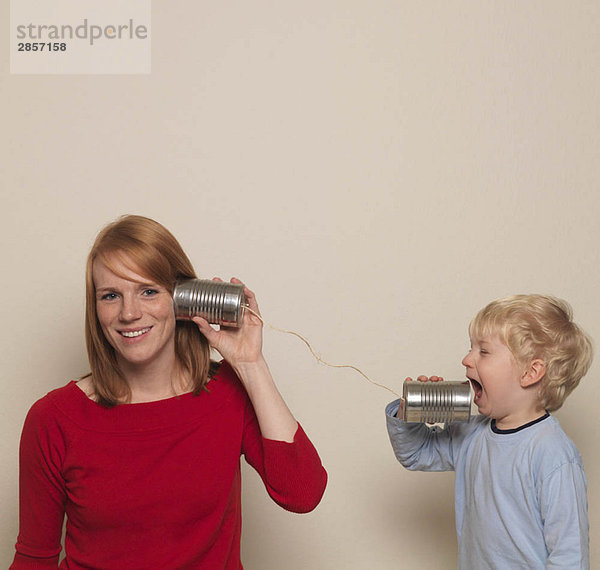 Mutter und Sohn spielen mit Dose telefonieren