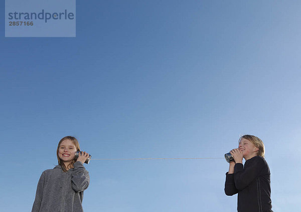 Kinder  die auf Blechdosen telefonieren