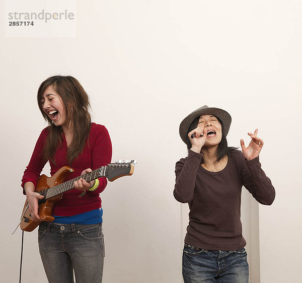 Zwei Frauen singen und spielen Gitarre