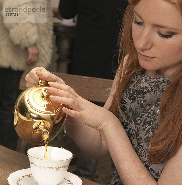 Junge Frau beim Tee im Café