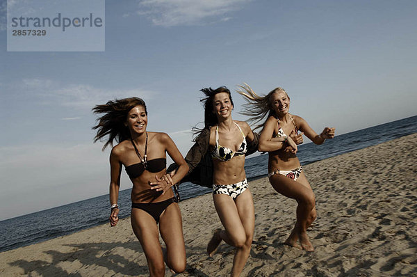 Teenager-Mädchen  die am Strand rennen.