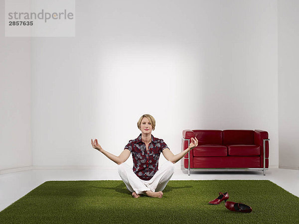 Frau meditiert im grünen Büro