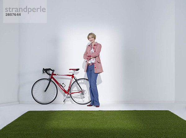 Frau steht neben dem Fahrrad