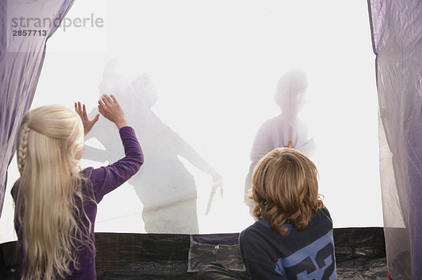 Kinder machen Schatten auf dem Zelt