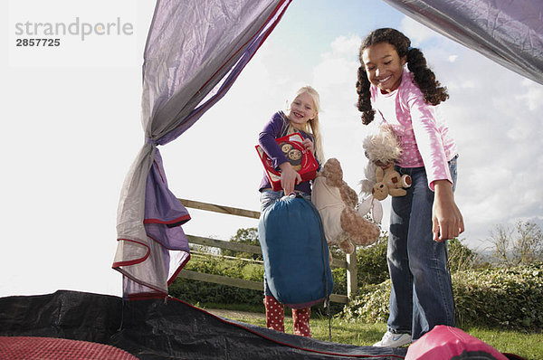 Mädchen stellen Schlafsäcke ins Zelt