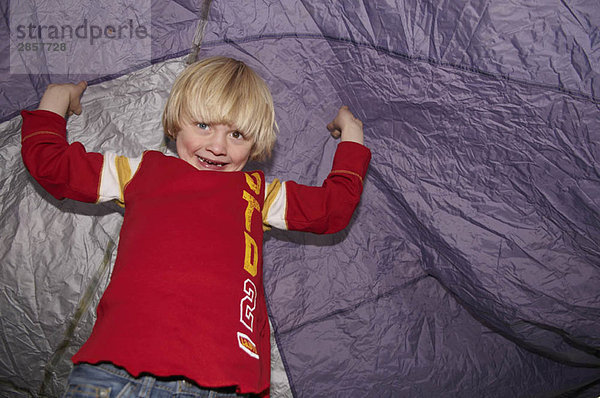 Junge spielt unter dem Zelt