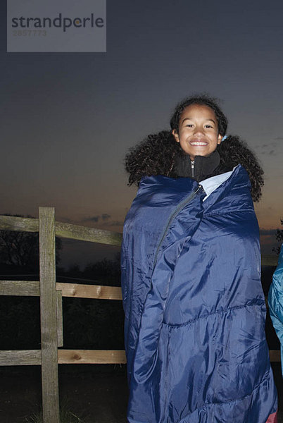 Mädchen im Schlafsack in der Abenddämmerung