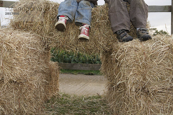 Junge Jungen auf Heuballen sitzend