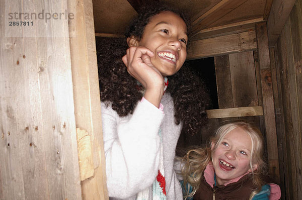 Zwei junge Mädchen an der Baumhaustür