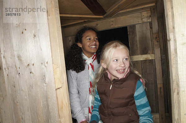 Zwei junge Mädchen betreten das Baumhaus