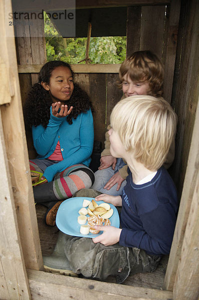 Kinder beim Picknick im Baumhaus