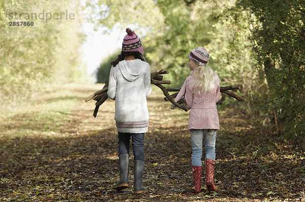 Zwei Mädchen mit Brennholz auf dem Land