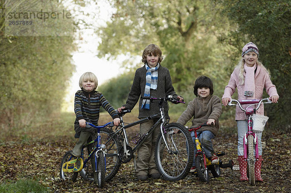 Kinder mit Fahrrädern auf dem Landweg