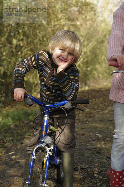 Junge mit Fahrrad auf dem Landweg